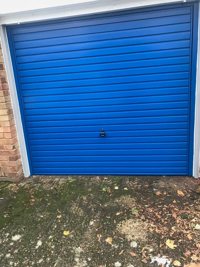 Modern horizontal rib garage door fitted to a rendered house in Surrey